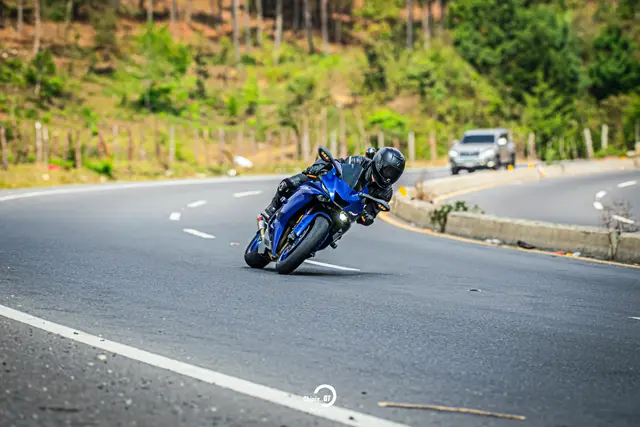 Leaning a blue sport bike into a right-hand curve on a mountain road