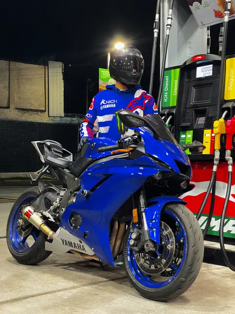 On the blue Yamaha at a petrol station at night, in a racing jacket
