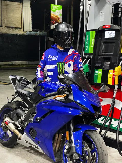 On the bike at a petrol station at night, seen from the side