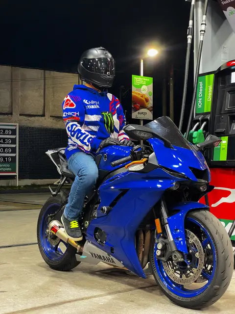 On the bike beside the fuel pumps at night