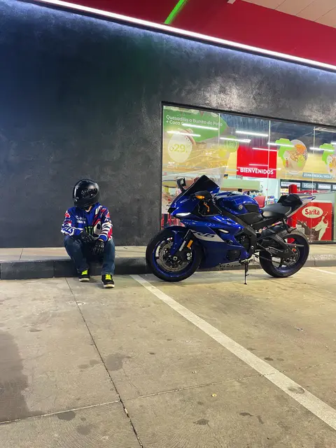 Crouching beside the bike outside a lit shop at night